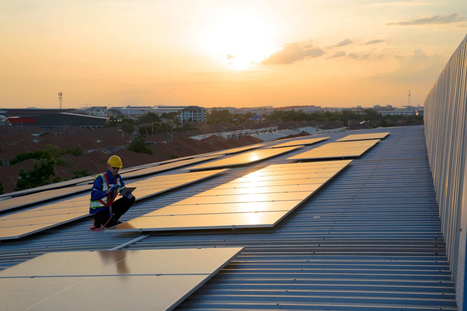 Blue collar worker is working at solar panel rooftop.